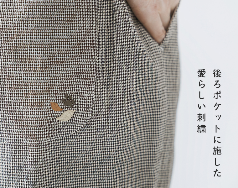 シャーリングテーパードパンツの細かな千鳥柄と、後ろポケットに施した刺繍がわかるアップ画像