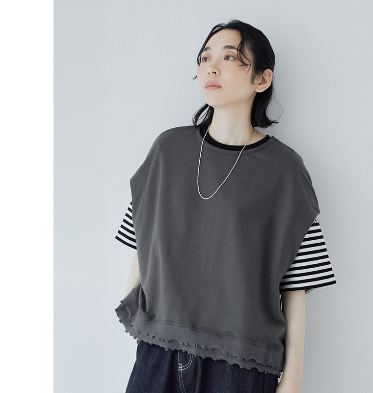 le ciel a temps douxミニミニ裏毛 裾メローTシャツベスト（チャコール）の着用アップ画像。裾のメローフリルとボーダーTシャツを重ねたレイヤードスタイルのディテールがわかるコーディネート写真