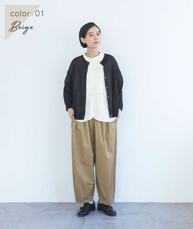 ベージュのいつものまあるいチノパンツに白いシャツと黒いカーディガンを合わせた女性モデルの全身スタイル