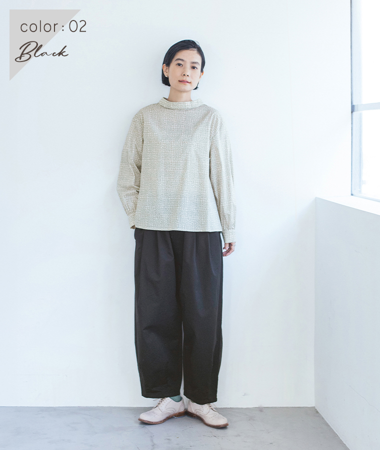 ブラックのいつものまあるいチノパンツにブラウスを合わせた女性モデルの全身スタイル