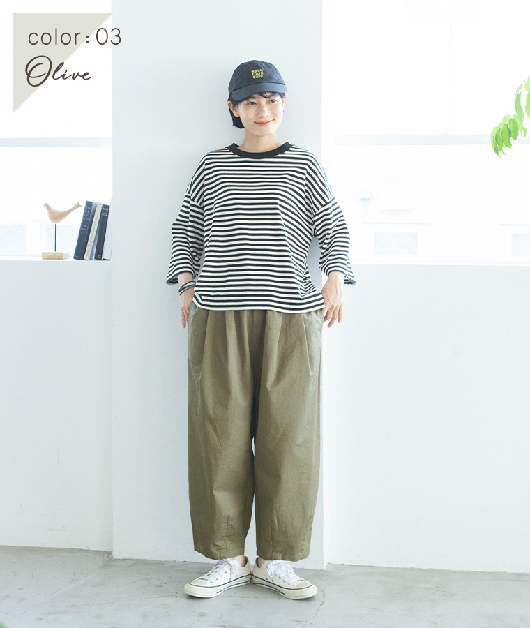 オリーブのいつものまあるいチノパンツにボーダーTシャツとキャップを合わせた女性モデルの全身スタイル