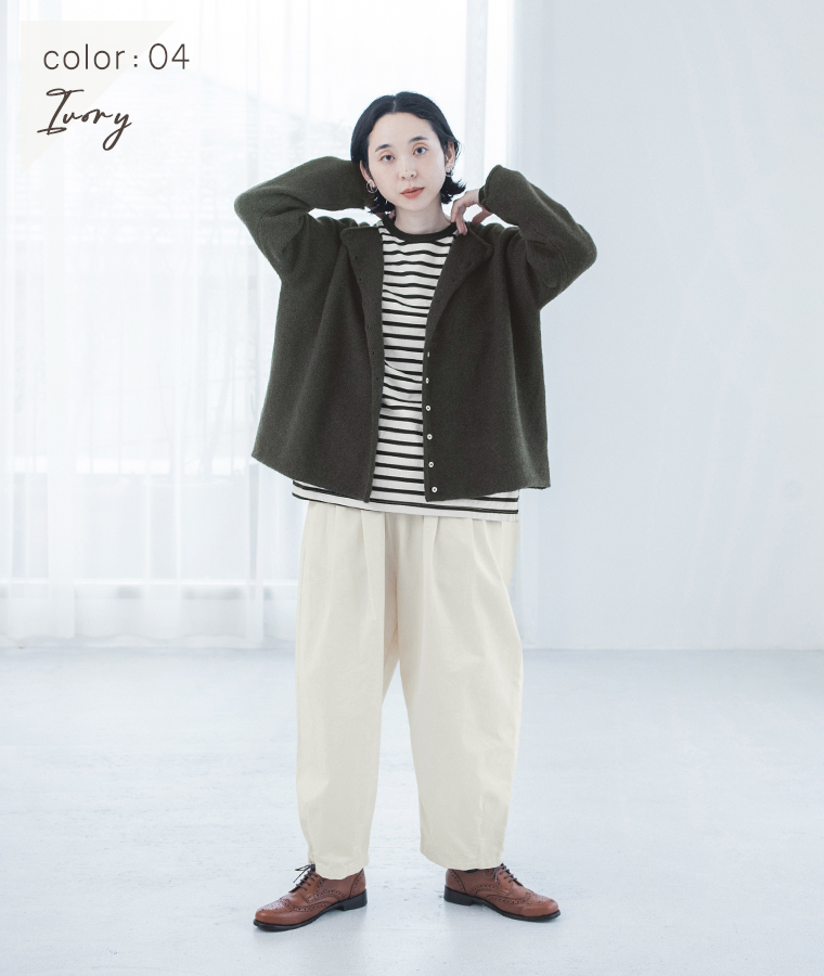 アイボリーのいつものまあるいチノパンツにブラウンのポロニットとレザーシューズを合わせた女性モデルの全身スタイル