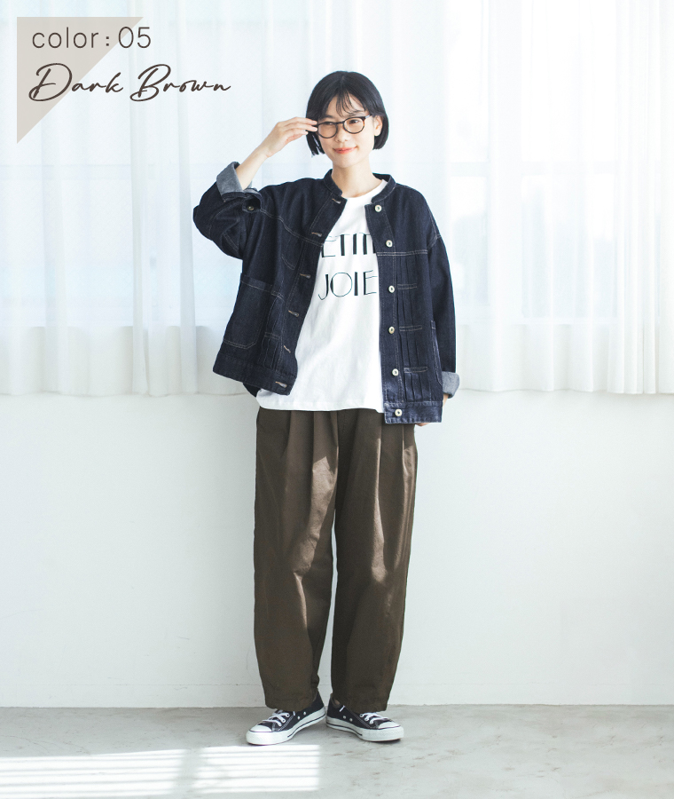 ダークブラウンのいつものまあるいチノパンツにロゴTシャツとデニムジャケットを合わせた女性モデルの全身スタイル
