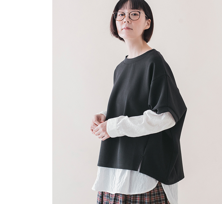 ブラックのカットベストのドロップショルダーとサイドスリットがわかる上半身の着用画像