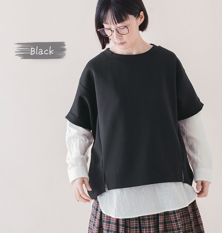 ブラックのカットベストに白シャツを重ね、チェック柄スカートを合わせたレイヤードスタイルの上半身画像