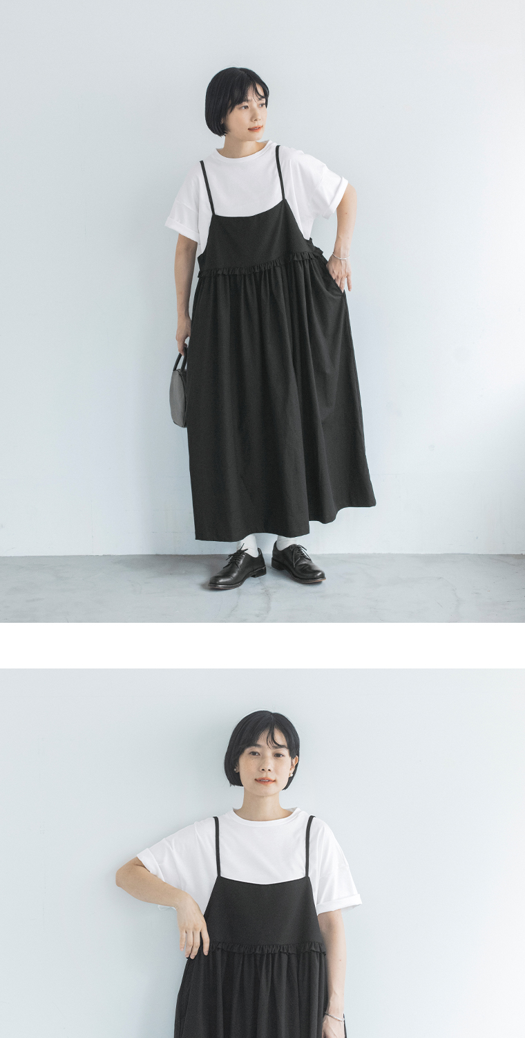 ブラックのジャンパースカートと白の半袖Tシャツを合わせた女性モデルのモノトーンスタイル