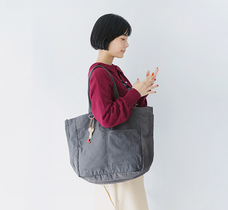 ダークグレーのコットンナイロン3wayトートを肩掛けしたサイドスタイル画像