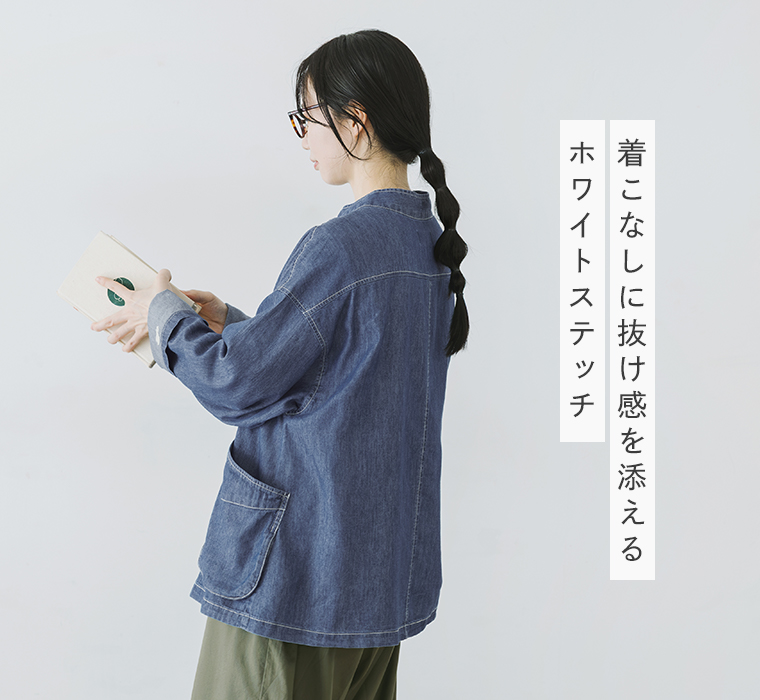 インディゴネイビーのスタンドカラージャケットのゆったりとしたシルエットとホワイトステッチが見える後ろ姿