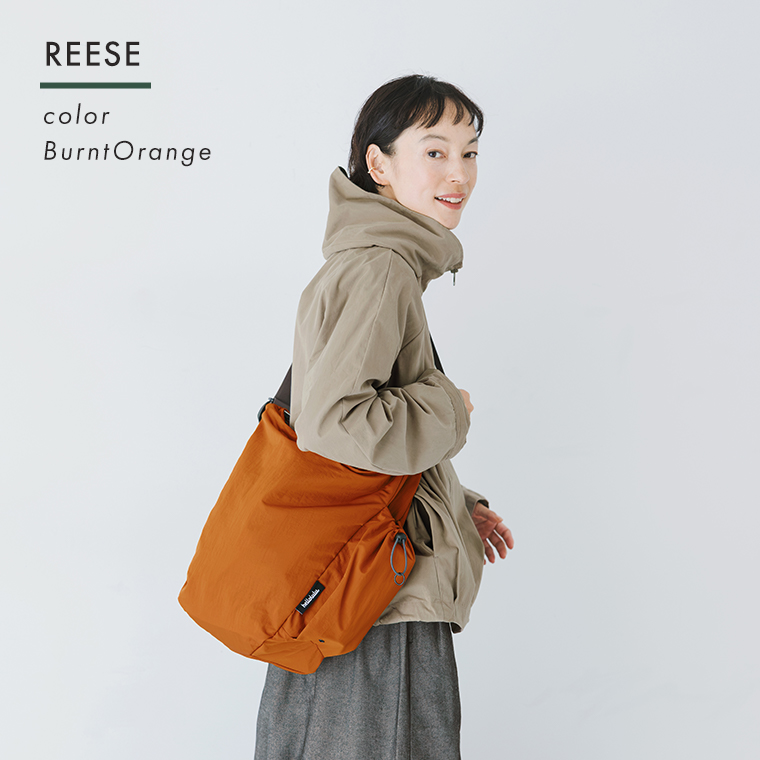 REESE バーントオレンジを肩掛けした女性モデルの着用イメージ