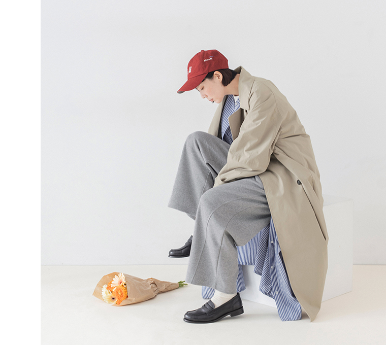 杢グレーのこなれスウェットカーブパンツのゆったりとしたシルエットを見せた座り姿のコーディネート