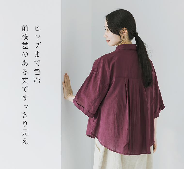 キャンブリック ボタニカル刺繍シャツの前後差のある丈と背面タックがわかる斜め後ろからの着用スタイル