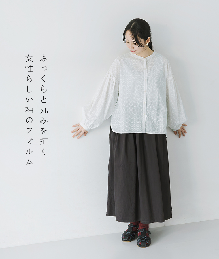 ホワイトのコットン総刺繍長袖ブラウスにブラックのロングスカートを合わせた全身コーディネート
