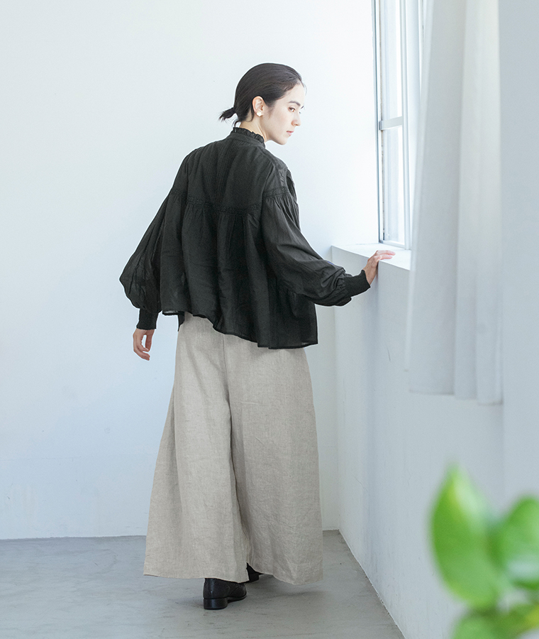 ピンタックレースブラウス（ブラック）とワイドパンツを着用した女性モデルの後ろ姿