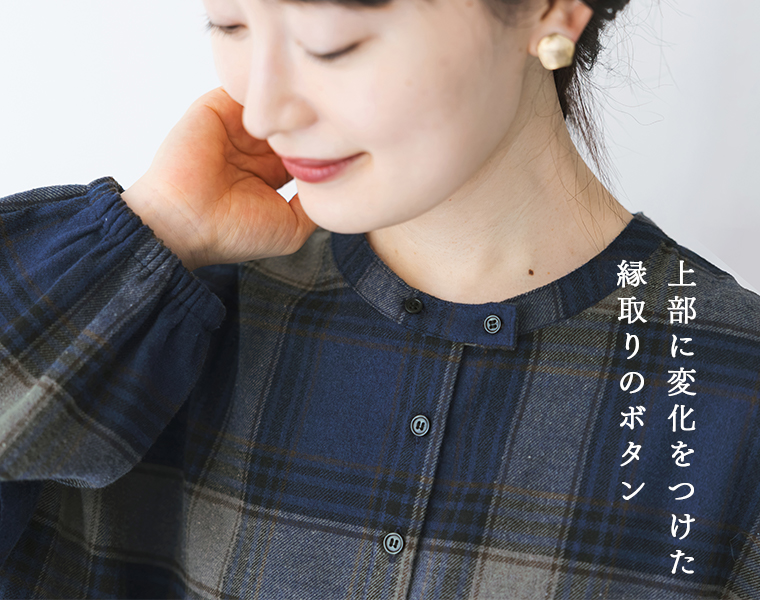 ネルウエスト切替長袖ギャザーワンピースの丸首と縁取りボタンを写した襟元のアップ