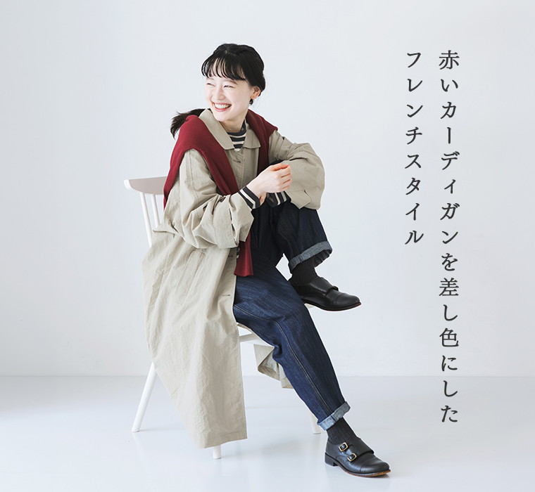 ナイロンナチュラルロングジャケットにデニムパンツを合わせ、赤いカーディガンを肩掛けした着こなし