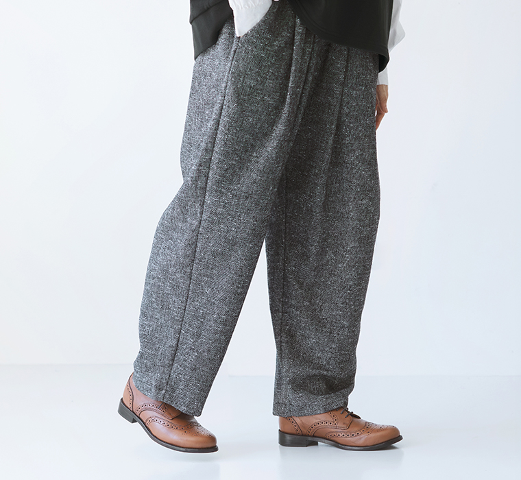 裾に向かってすっきりとしたウール混ネップテーパードパンツの横向き着用カット