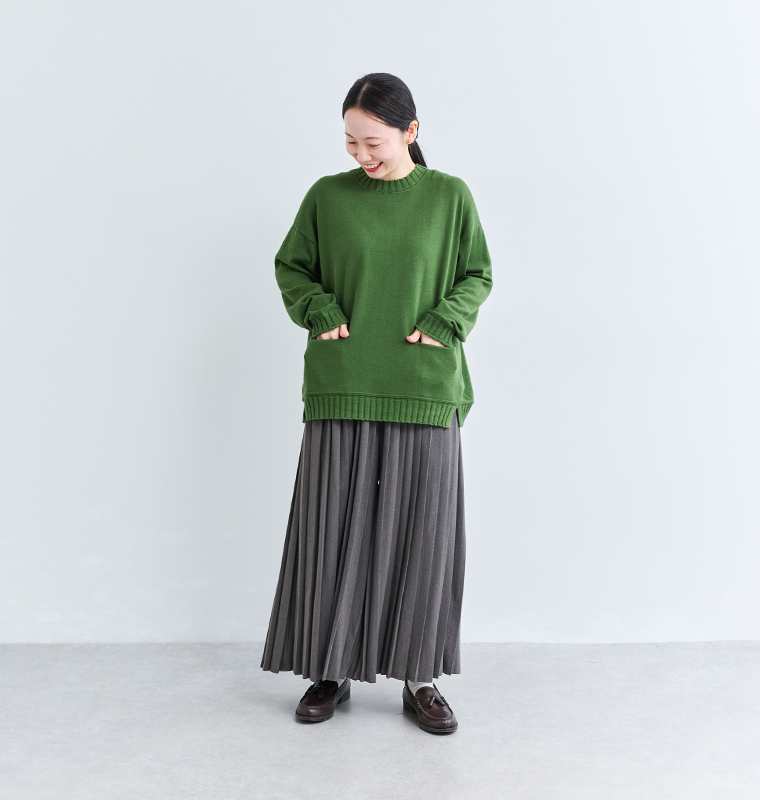 &yarn1枚で着映えるプリーツパンツにグリーンのニットを合わせたコーディネート