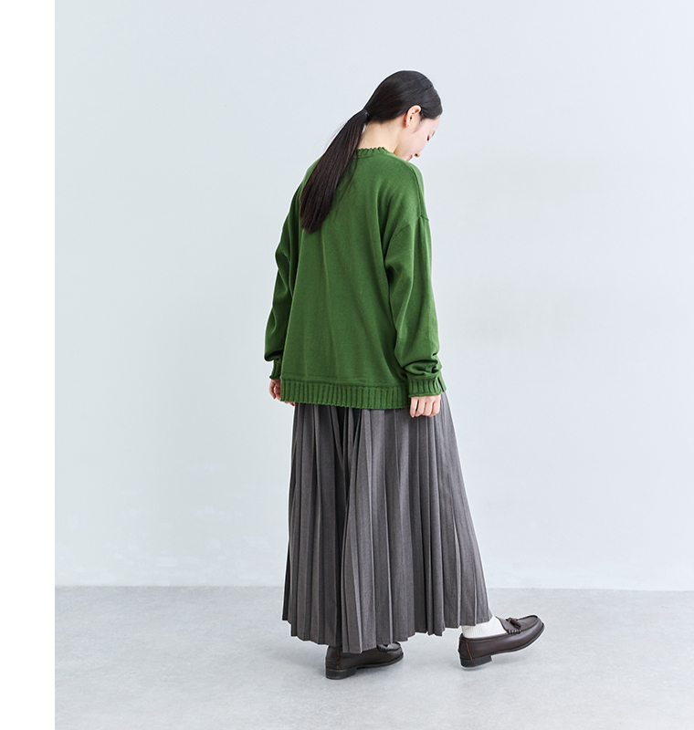 &yarn1枚で着映えるプリーツパンツにグリーンのニットを合わせたバックスタイル