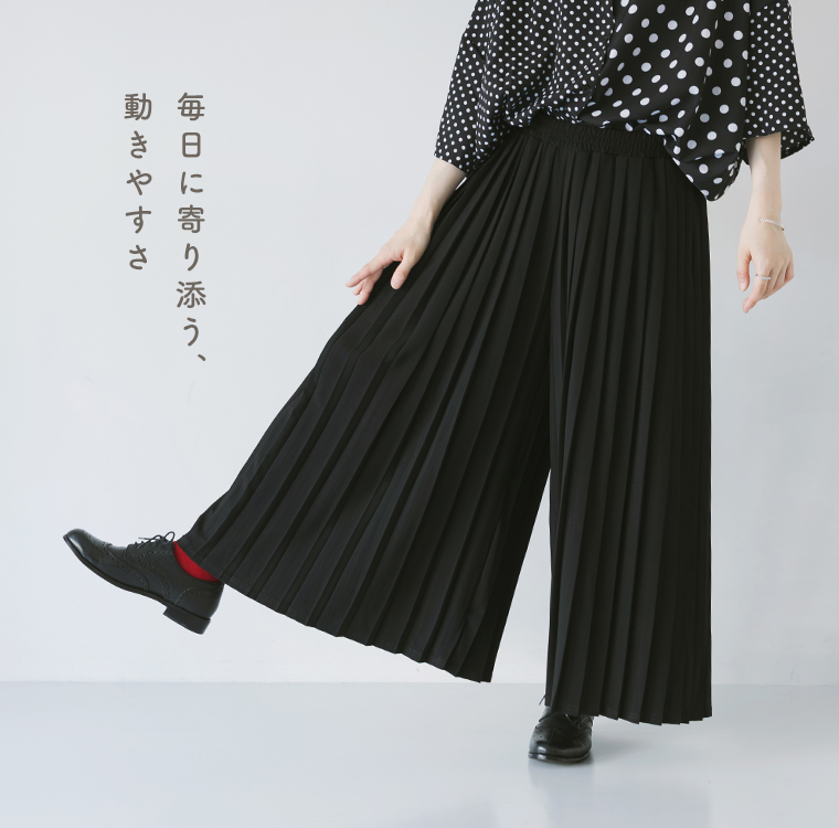 &yarn1枚で着映えるプリーツパンツの着用イメージ。ブラックのプリーツが美しく広がる、動きやすさと上品さを兼ね備えた商品画像