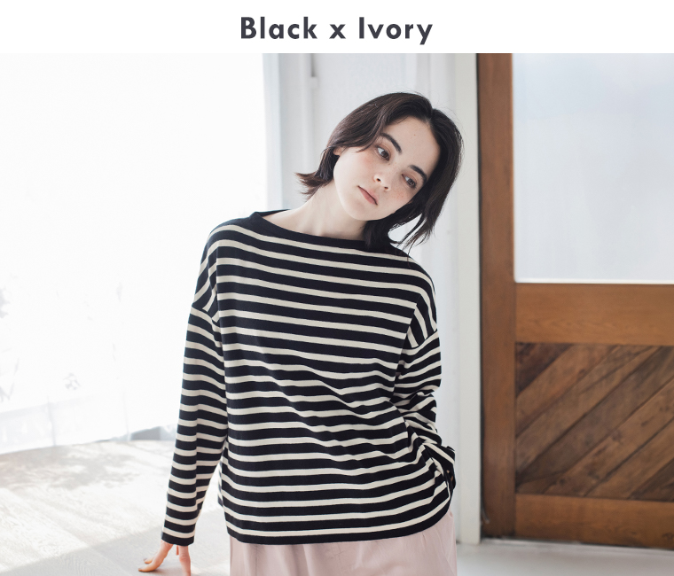 ブラック×アイボリーのボーダープルオーバーを着た女性モデルの上半身