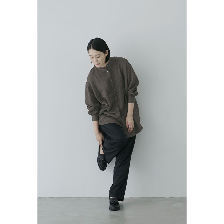 ブラウンのピンタックロングシャツの袖をたくし上げた着こなし