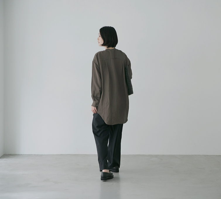 ブラウンのピンタックロングシャツを着用した後ろ姿