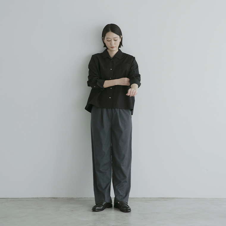 ブラックのタイプライターシャツの袖をまくった正面の全身スタイル