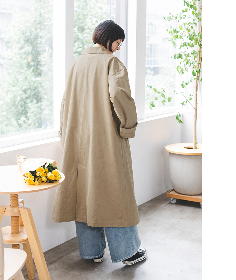 ベージュのわたしの定番ステンカラーコートのゆったりとした後ろ姿を写した着用カット