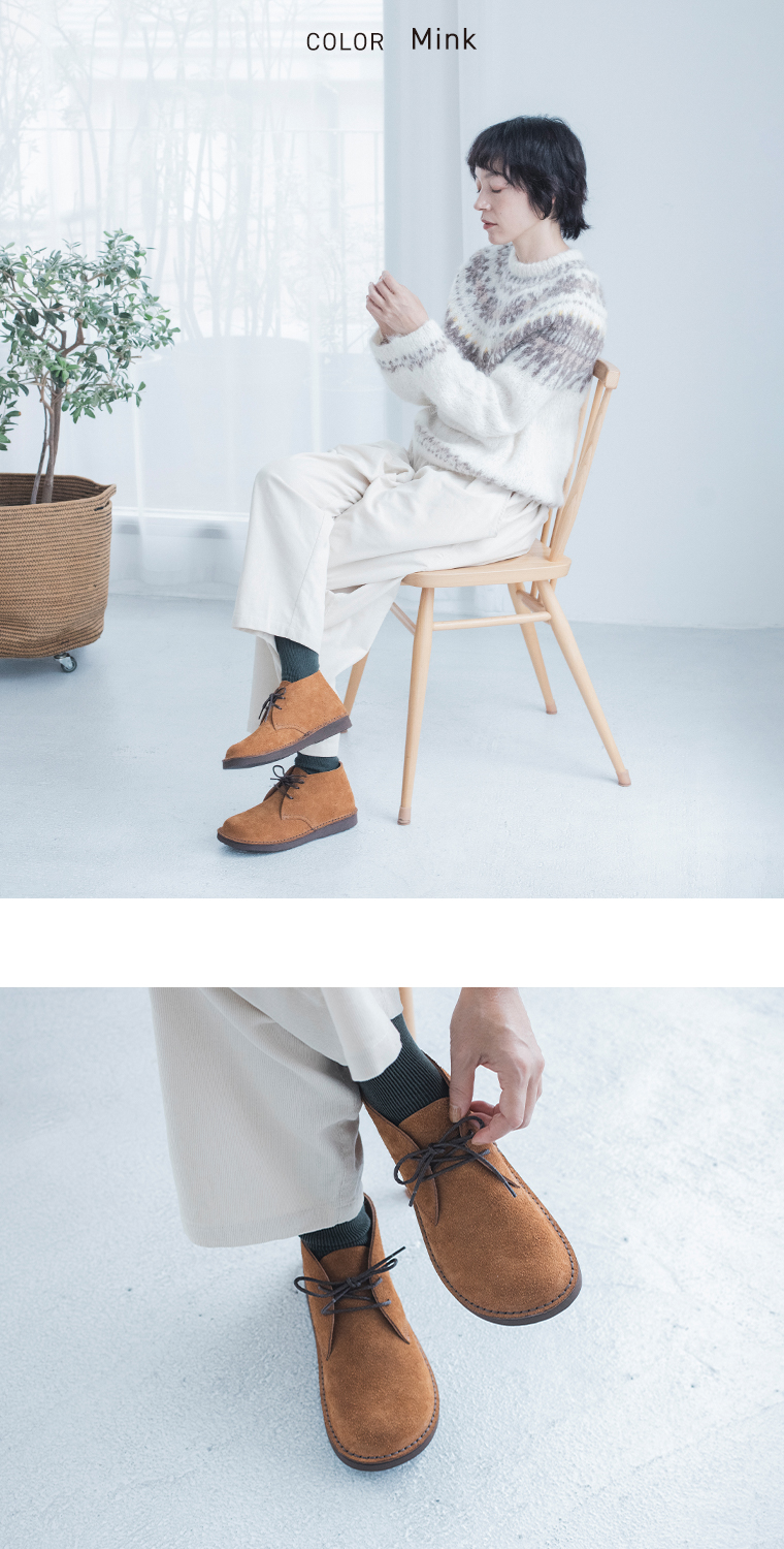 ミンクのチャッカブーツを柄入りニットと白いパンツに合わせた着こなし