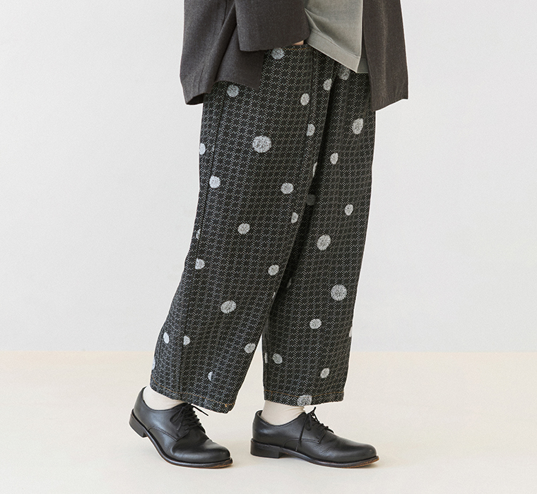 デニムサイドポケット付きパンツのゆったりとしたシルエットとドット刺繍がわかる斜め前からの着用カット