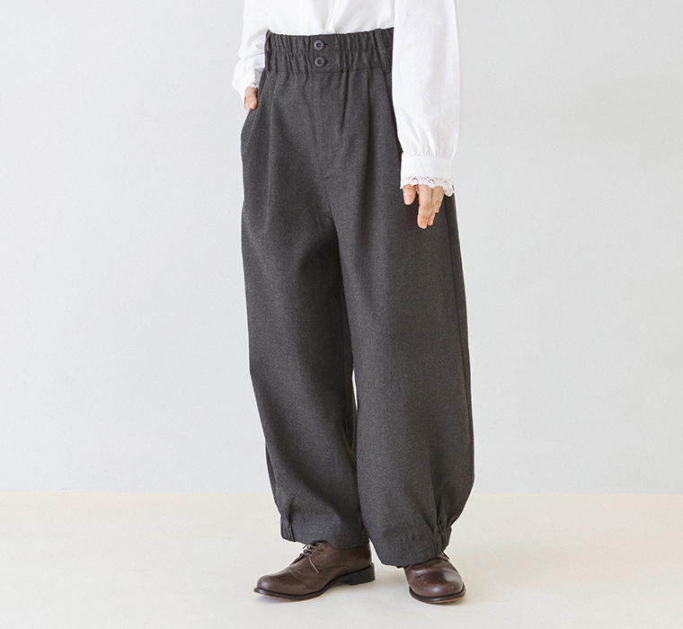 裾ゴムパンツのフロントボタンと裾に丸みを持たせたシルエットがわかる正面着用カット