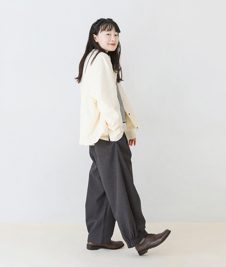 裾ゴムパンツをアイボリーのカーディガンと合わせたモデルの横向き全身コーディネート