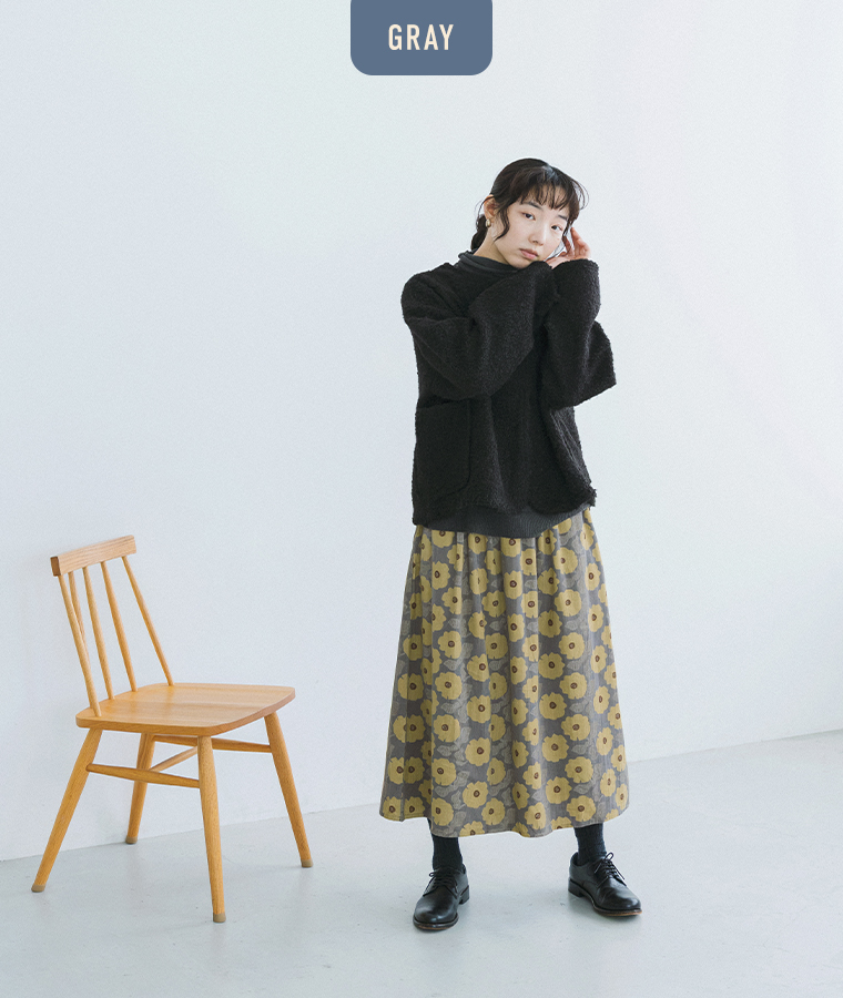 グレーの花柄スカートにブラックのジャケットと革靴を合わせた着こなし
