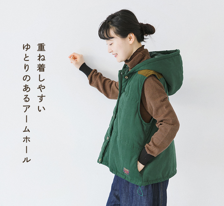 フード付き中わたベストのゆとりあるアームホールと立体的なフード、サイドシルエットがわかるモデルの横向き着用カット