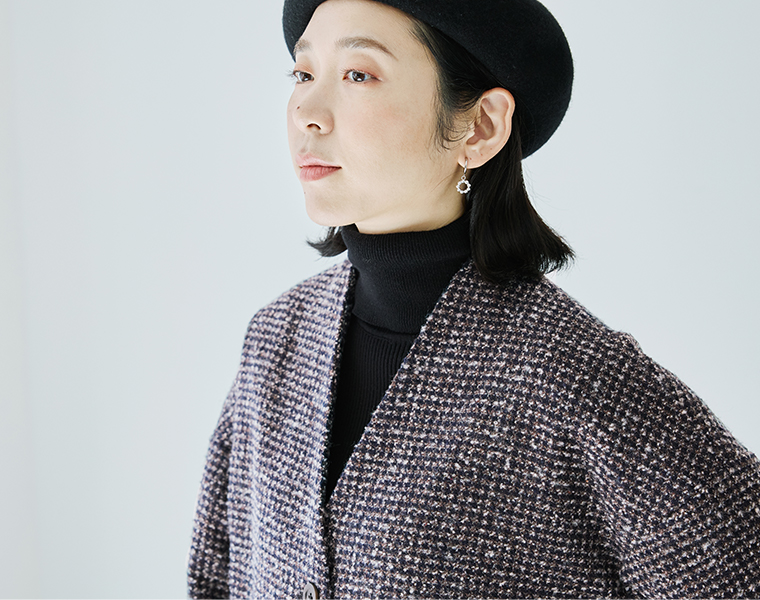 黒のタートルネックを重ねたジャケットの襟元とVネック