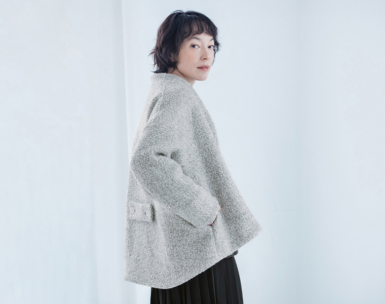 グレーのジャケットの背面のベルトと後ろ下がりの裾
