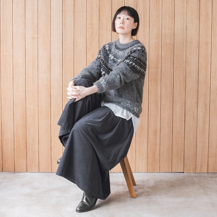 グレーの柄ニットとダークネイビーのワイドパンツを合わせた大人ナチュラルな冬の着こなし