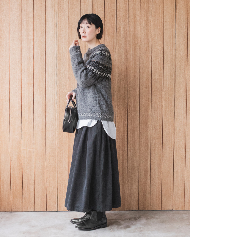 &yarnのダークネイビーのタックワイドパンツを使った横向きの冬コーデ。ニットとシャツの重ね着スタイル