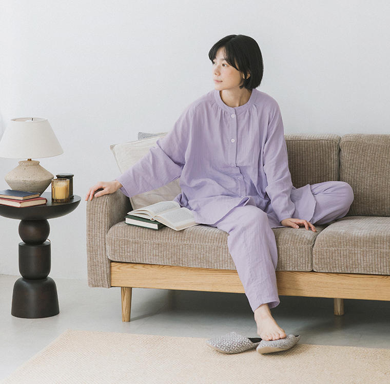 着る保湿クリーム(R)×TERAX 温活・血行促進パジャマを着用し、ソファでくつろぐパープルカラーのコーディネートイメージ