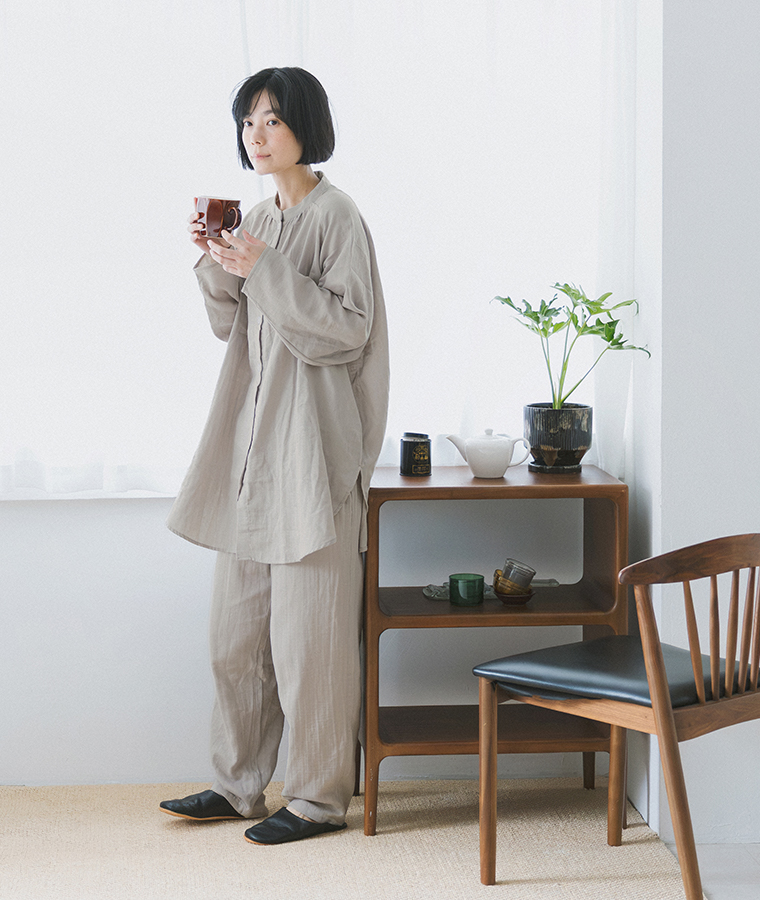 着る保湿クリーム(R)×TERAX 温活・血行促進パジャマ（グレー）の着用イメージ。マグカップを手にしたリラックススタイル
