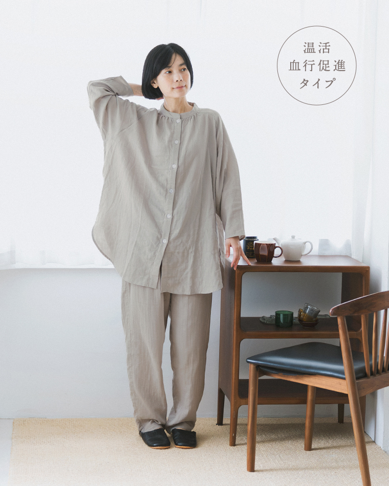 着る保湿クリーム(R)×TERAX 温活・血行促進パジャマ（グレー）の着用イメージ。テーブル横に立った正面コーディネート