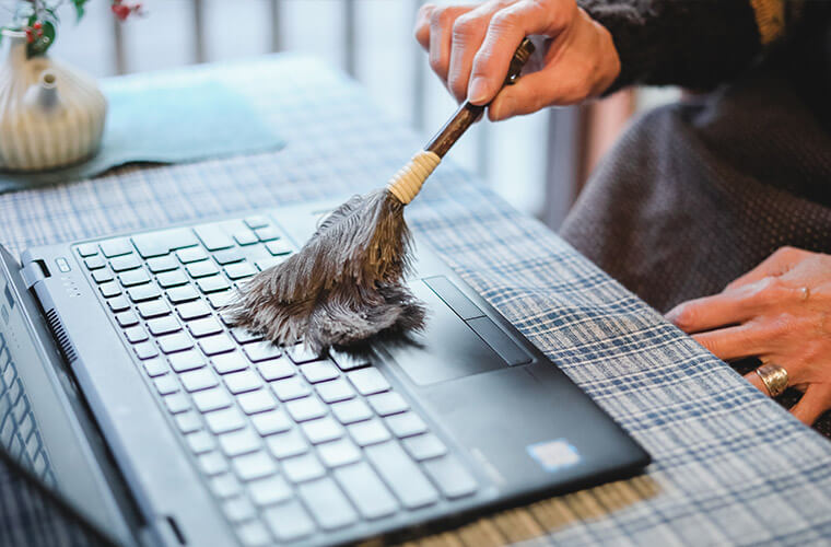 松野屋のダチョウ羽はたきミニでパソコンのキーボードのほこりを取る様子　拡大画像